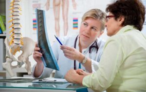 Patient discusses back pain with a chiropractor during a calm, professional examination.